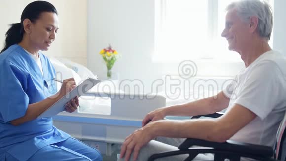 专业的好医生和坐在轮椅上的人谈话视频的预览图