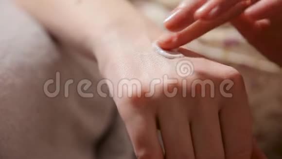 女人把保湿霜涂在她的手上美甲和水疗美甲的概念美容指甲柔软的皮肤护肤品视频的预览图