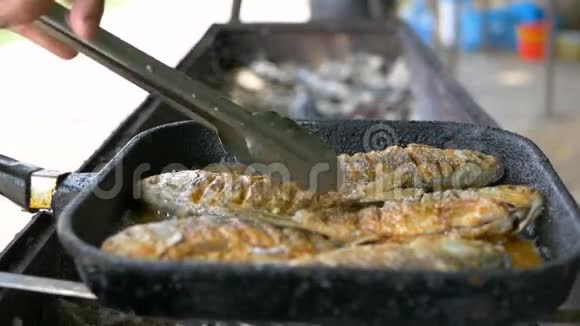 在煎锅和烤架里用油煮鱼在露天煎鱼专业餐饮美味脆脆的食物视频的预览图