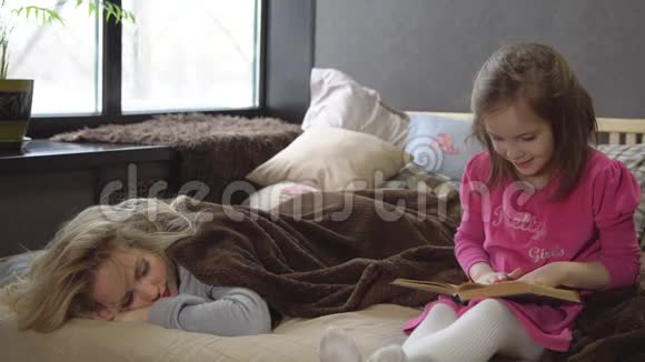 妈妈睡觉的时候女儿在床上看书视频的预览图