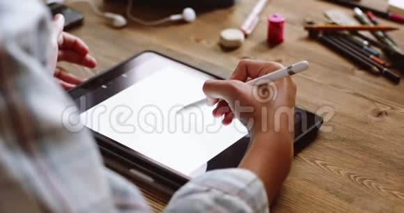 年轻女子在平板电脑上画画视频的预览图