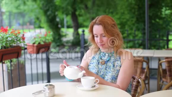 幸福的微笑女人做绿茶户外夏季背景健康饮食理念浅深的田野视频的预览图