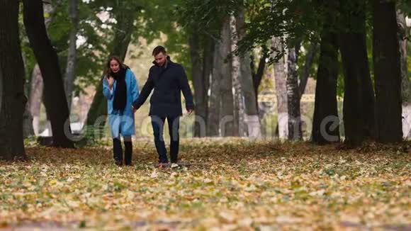 一对迷人的情侣在秋天公园散步视频的预览图