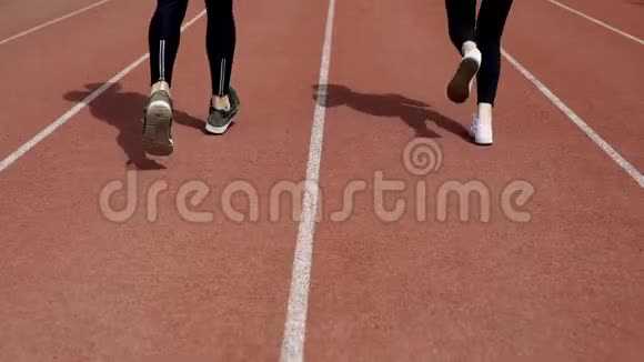 女人们一起在体育场跑道上慢跑视频的预览图