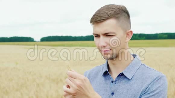 一位成功的年轻农民手里拿着麦穗的画像视频的预览图