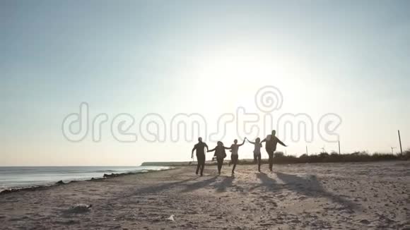 快乐的朋友在海岸线上奔跑视频的预览图