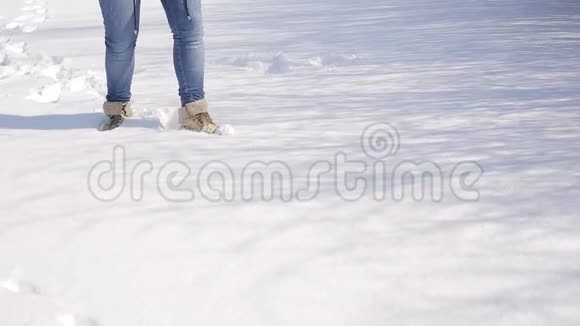 穿着黑色雪靴行走的女性腿在冬天的一天尽管下雪视频的预览图
