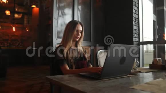 快乐的年轻女子在咖啡馆里喝咖啡使用平板电脑视频的预览图