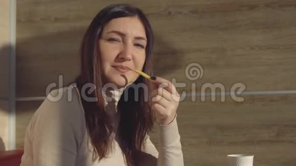 不健康饮食的概念在咖啡馆吃薯条的黑发女青年视频的预览图