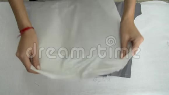 双手用特制的裁缝熨斗摩擦灰色的布料视频的预览图