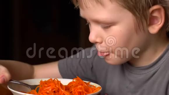 有趣的金发男孩正在他弟弟旁边的厨房里吃韩国胡萝卜沙拉孩子们在一起很快乐视频的预览图