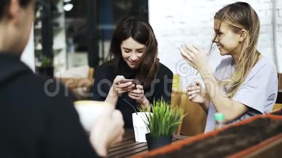 咖啡馆里的三个年轻人分享他们的社交媒体经历视频的预览图