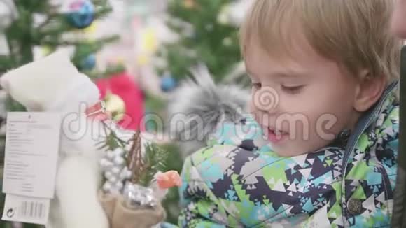 父子俩在商店里挑选圣诞礼物在圣诞节前出售玩具和圣诞树视频的预览图