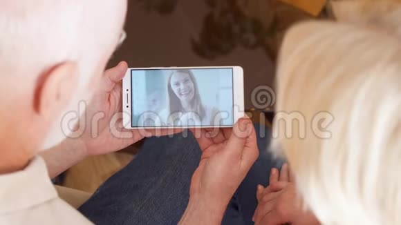 在家的老夫妇通过信使应用程序与女儿在国外进行视频聊天视频的预览图