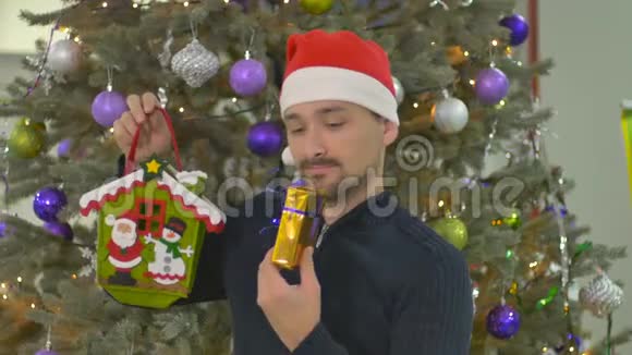 戴着圣诞老人帽子的大胡子把礼物放进节日的包装里视频的预览图