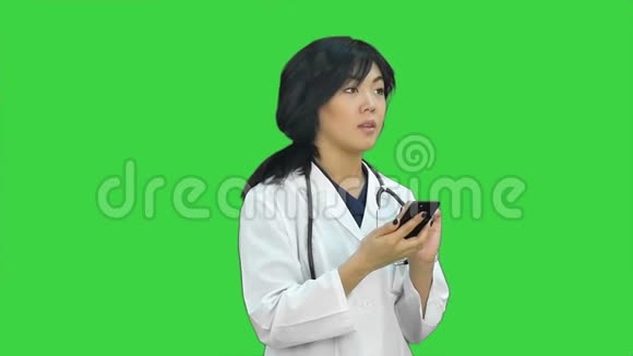穿着白色外套和听诊器在绿色屏幕上看x射线的女性亚洲医生Chroma键视频的预览图