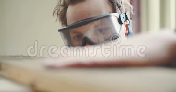 木工戴防护眼镜检查木板视频的预览图