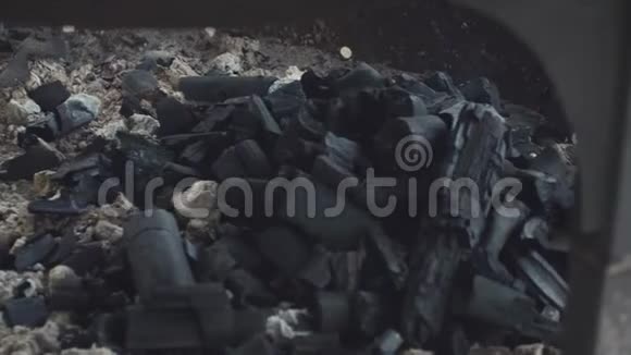 一片被灰灰覆盖的煤块放在一个大的扁平的黑色胸罩里视频的预览图