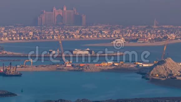 在日出时分从阿拉伯联合酋长国迪拜的一个屋顶上俯瞰棕榈岛令人叹为观止的空中景色视频的预览图