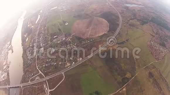 跳伞员在多云的天空中跳伞绿色的田野城市河流极限运动视频的预览图