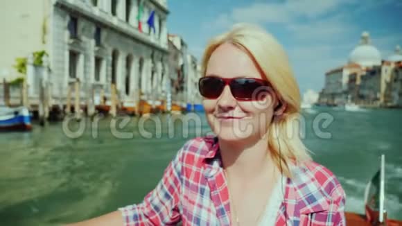 意大利威尼斯一位妇女在大运河上游船的肖像她微笑着欣赏城市的景色视频的预览图