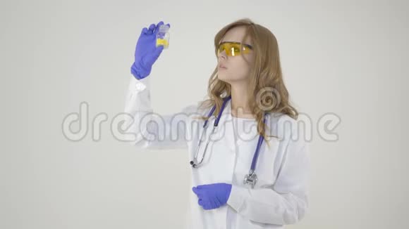 年轻护士白色背景上拿着一罐药丸的漂亮女医务工作者视频的预览图