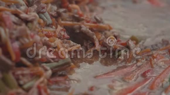在大平底锅中搅拌和炖煮的蔬菜和肉视频的预览图