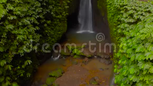 在印度尼西亚巴厘岛的丛林里的莱克勒克瀑布的鸟瞰图相机倾斜视频的预览图