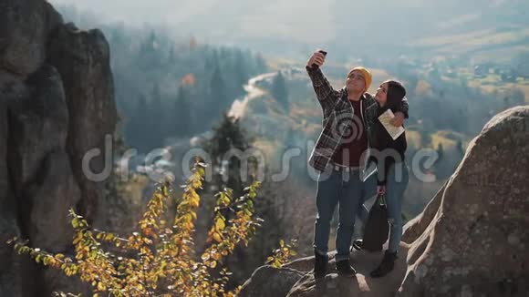 恋爱中的年轻夫妇站在岩石上拍了一张自拍肖像拜访著名游客的男人和女人视频的预览图
