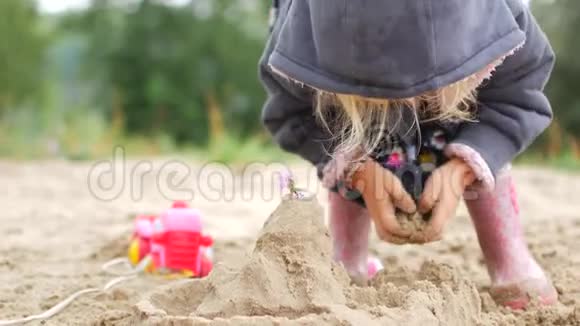 孩子们在海滩上玩沙子小女孩独自在海滩上建造沙堡视频的预览图