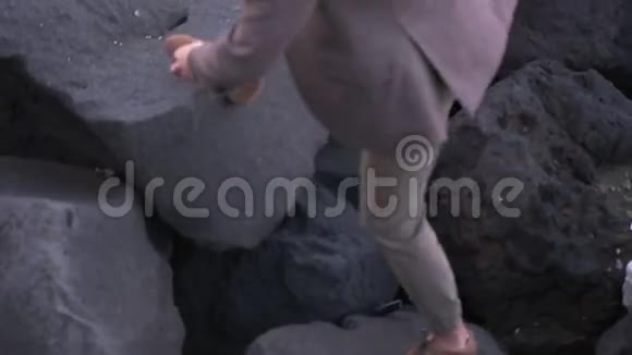 穿西装的人在岩石上行走视频的预览图