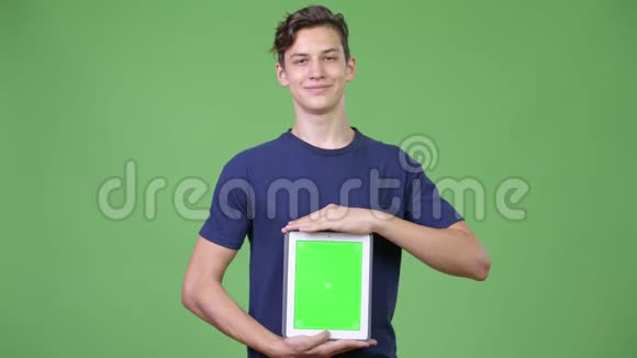年轻英俊的少年展示数码平板电脑视频的预览图