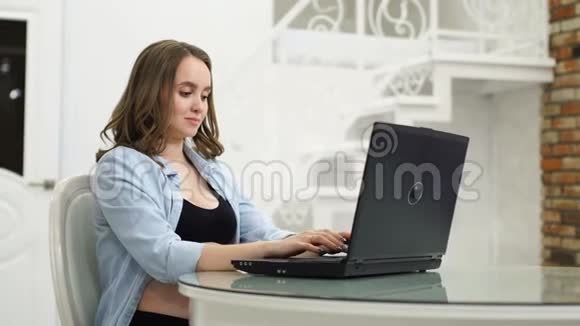 孕妇在产假期间从事业务坐在电脑前抚摸着她的肚子和她说话视频的预览图