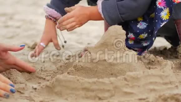 孩子们在海滩上玩沙子小女孩独自在海滩上建造沙堡视频的预览图