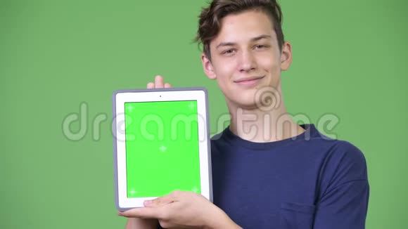 年轻英俊的少年展示数码平板电脑视频的预览图