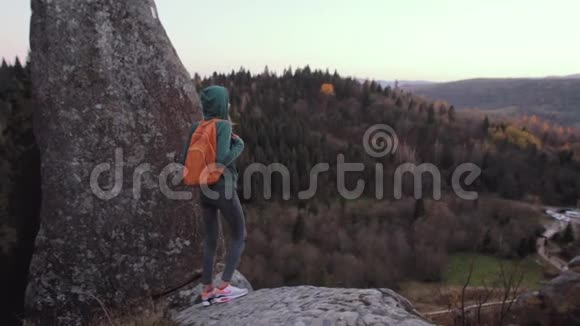 站在悬崖边的女人站在森林背景下视频的预览图