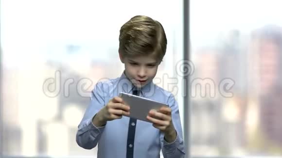 小男孩在手机上玩网络游戏视频的预览图