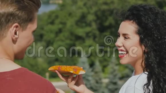 爱情中可爱的肖像情侣玩得开心吃披萨视频的预览图