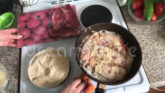 肉片用热煎锅炒有热脂肪的飞溅厨师这时用海绵擦拭盘子视频的预览图