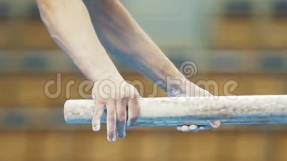 穿白色粉笔粉的运动员手在酒吧表演视频的预览图