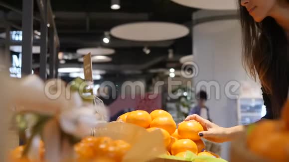 年轻的混合种族妇女采摘和选择橘子水果在杂货店超市商店4K视频的预览图