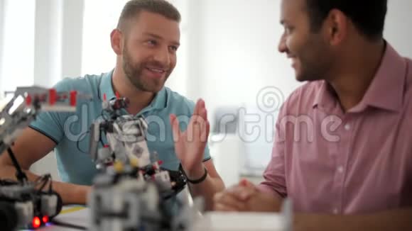 放射男性同事讨论机器人装置的优点视频的预览图