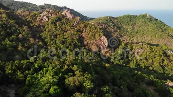 热带岛屿的丛林和山脉科岛火山岩地形上绿色丛林和巨大巨石的无人视野视频的预览图