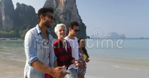 人们在沙滩上散步谈两对情侣在度假时拥抱快乐的男女游客视频的预览图