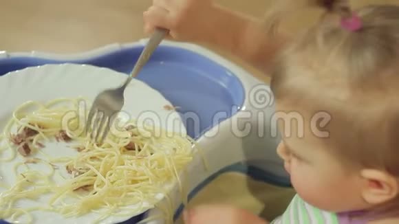 可爱的小女孩用叉子吃肉意大利面视频的预览图