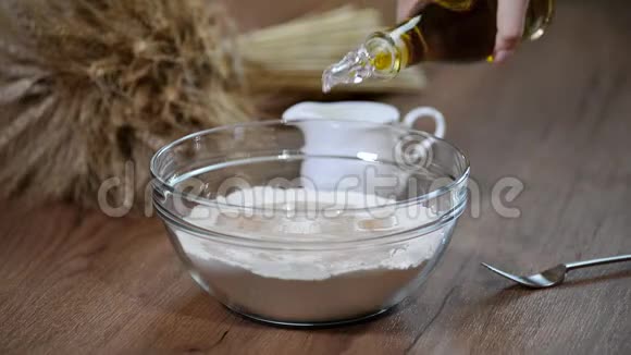 把橄榄油倒入一碗面粉中烹饪面包视频的预览图