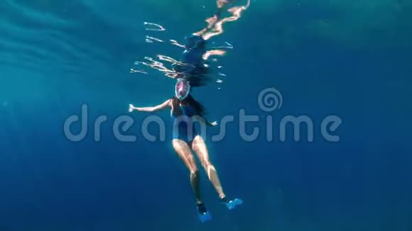 时尚和运动的女孩独自在海洋深处潜水浅棕色的浅黑色在蓝色海洋深处潜水视频的预览图