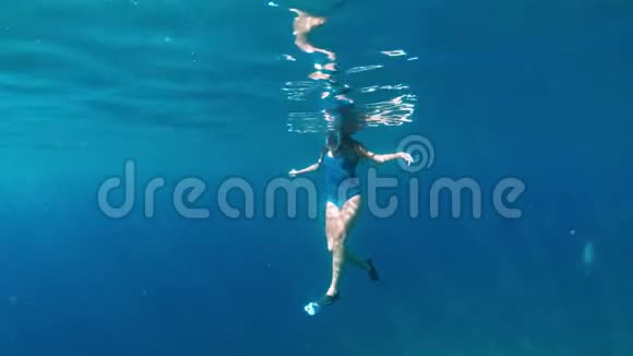 时尚和运动的女孩独自在海洋深处潜水浅棕色的浅黑色在蓝色海洋深处潜水视频的预览图