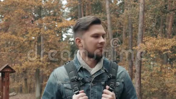 秋天森林中的小胡子男的肖像带有旅游背包秋天风格旅行生活方式视频的预览图