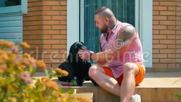 帅哥肌肉男在家门口用樱桃喂狗视频的预览图